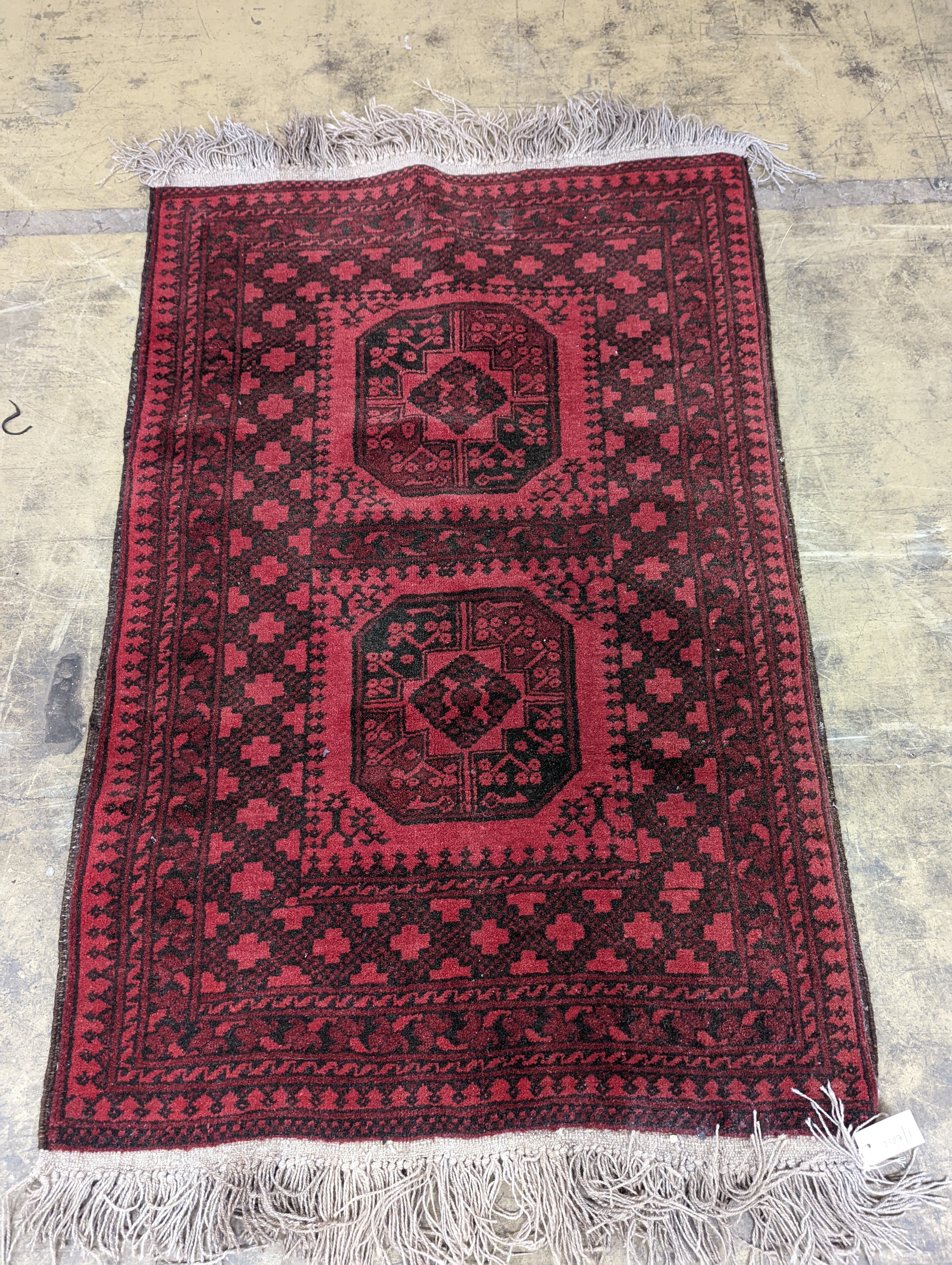 An Afghan red ground rug, 140 x 96cm